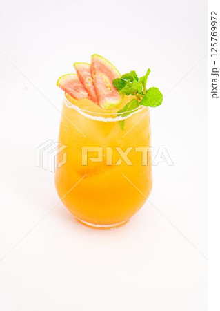orange peach cocktail with strawberry slices and fresh mint served in transparent glass over ice on white background. High quality photo 125769972
