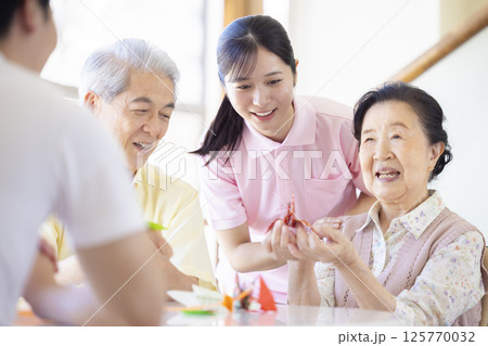 介護イメージ 折り紙を折るシニアと介護士 介護イメージ 折り紙を折るシニアと介護士 125770032