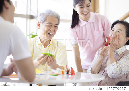介護イメージ 折り紙を折るシニアと介護士 介護イメージ 折り紙を折るシニアと介護士 125770037