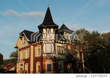 traditional european buildings and village structures including historic house and wood cross post under blue sky. High quality photo 125770373