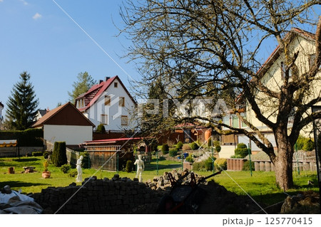 european village garden decorated with white easter bunny statues and spring greenery under clear sky. High quality photo european village garden decorated with white easter bunny statues and spring greenery under clear sky. High quality photo 125770415