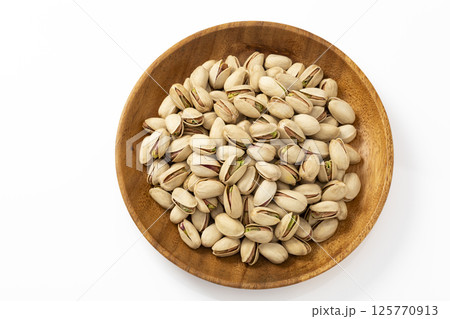 木皿に盛った白バックのピスタチオ 125770913