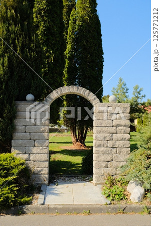 european village garden decorated with white easter bunny statues and spring greenery under clear sky. High quality photo 125771212