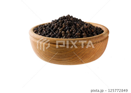 black pepper seeds in a wooden bowl isolated on white background. black pepper seeds in a wooden bowl isolated on white background. 125772849