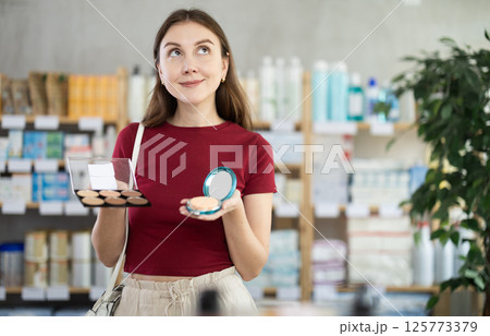 Young woman chooses cosmetics at pharmacy Young woman chooses cosmetics at pharmacy 125773379