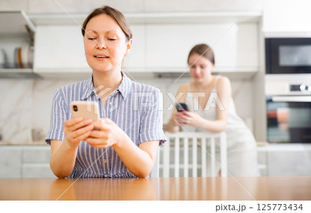 Happy mom writing a message on smartphone Happy mom writing a message on smartphone 125773434