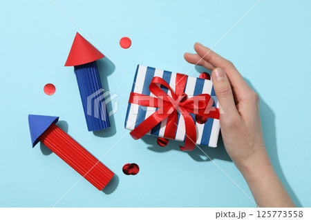 Paper fireworks with a gift on a blue background 125773558