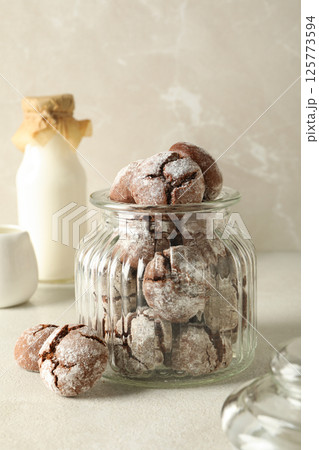 Delicious Grinkle cookies in a glass jar, on a light background. Delicious Grinkle cookies in a glass jar, on a light background. 125773594