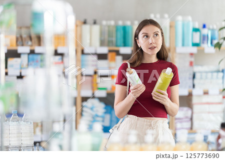 woman chooses a natural shampoo at the pharmacy woman chooses a natural shampoo at the pharmacy 125773690