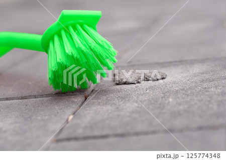 Green brush for cleaning. Stone tiles, paving Green brush for cleaning. Stone tiles, paving 125774348
