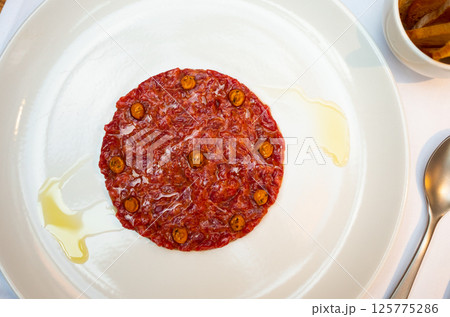 Exquisite French dish is veal tartare decorated with pickled capers Exquisite French dish is veal tartare decorated with pickled capers 125775286