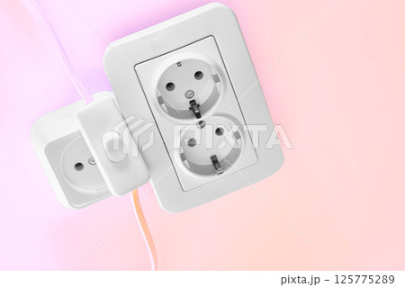 Electrical sockets for connecting devices and a switch on pink 125775289