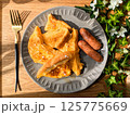 グレーのお皿にのったフレンチトーストとソーセージの朝食（正面） 125775669