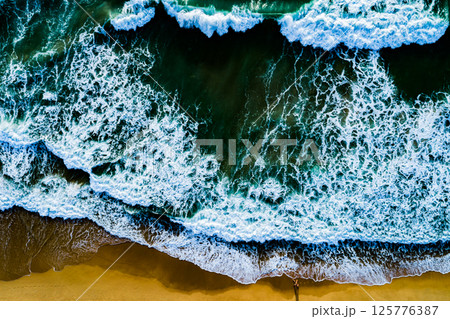 Top view Dark waves crashing on sandy shore beach background,Amazing waves sea nature background 125776387