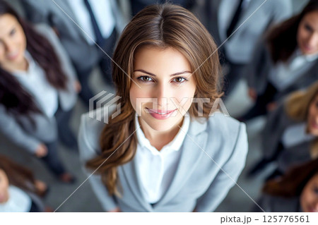 Top view of a brunette woman in an office setting, symbolizing career growth and feminist empowerment among colleagues. Empowered woman at work, viewed from above 125776561
