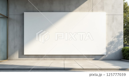Blank wall surface on modern building exterior with natural light casting shadow in an urban setting 125777039