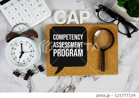 CAP - Competency Assessment Program acronym with calculator, alarm clock and magnifying glass, business concept background CAP - Competency Assessment Program acronym with calculator, alarm clock and magnifying glass, business concept background 125777134