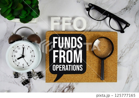 FFO - Funds From Operations acronym with alarm clock and magnifying glass, business concept background FFO - Funds From Operations acronym with alarm clock and magnifying glass, business concept background 125777165