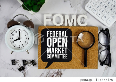 FOMC - Federal Open Market Committee acronym with calculator, alarm clock and magnifying glass, Business and Financial concept background 125777170