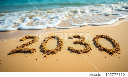 Sand numbers represent the year 2030 along a tranquil beach shore with gentle waves lapping at the sand 125777530