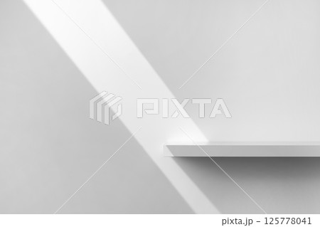 Beauty cosmetics product presentation scene made with empty white shelf with ray of sunlight on it.  125778041