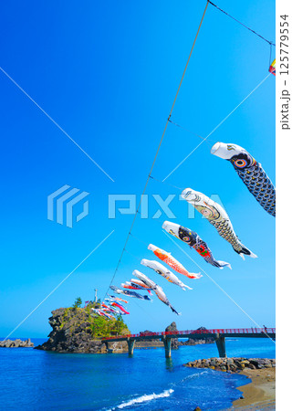 糸魚川市能生の弁天岩と青い海、空に舞う鯉のぼり|5月の風景 糸魚川市能生の弁天岩と青い海、空に舞う鯉のぼり|5月の風景 125779554