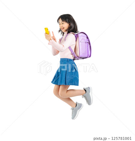 スマホを使いながらジャンプする小学生の女の子　手作業で精密に切り抜いた背景透過全身写真PNG 125781001