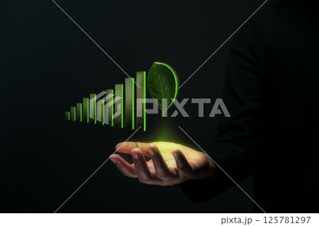 Sustainable Business. Green Energy, Renewable in Environmental Concept. Hand Levitating Glowth Green Bar Chart and Make a Green Leaf as a Goal 125781297