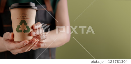 Recycled Packaging Concept. Barista Holding a Hot Cup of Coffee. Zero Waste Materials. Environment Care, Reuse, Renewable for Sustainable Lifestyle Recycled Packaging Concept. Barista Holding a Hot Cup of Coffee. Zero Waste Materials. Environment Care, Reuse, Renewable for Sustainable Lifestyle 125781304
