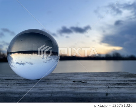 Sunset Reflected in Lensball on Wooden Dock 125781326