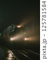 A train is traveling smoothly down the tracks under the night sky 125781584