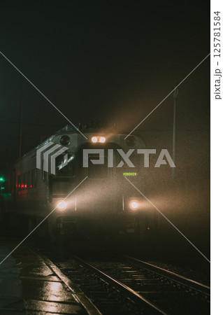 A train is traveling smoothly down the tracks under the night sky 125781584