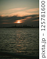 A sunset over water with a city in the background 125781600