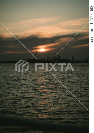 A sunset over water with a city in the background 125781600