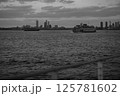 A black and white photo of a ferry with a city skyline 125781602