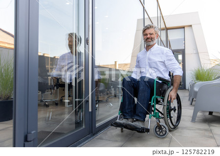 Mature man on a wheelchair looking determined and confident Mature man on a wheelchair looking determined and confident 125782219