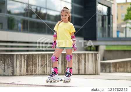 Child skating on roller-blades in stadium having fun 125782282