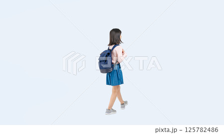 リュックを背負って歩く小学生の女の子の後ろ姿の全身写真 125782486