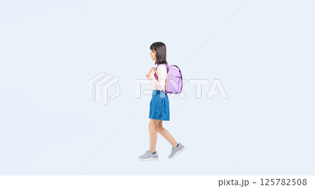 横向きに歩くランドセルを背負った小学生の女の子の全身写真 125782508