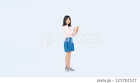 スマホを使う女の子の全身写真 125782527