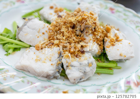 Top view of Steamed sea bass with dipping sauce, focus selective 125782705