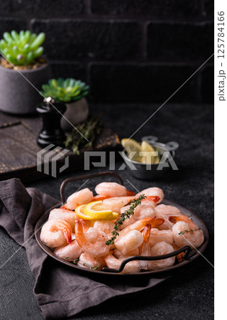 Frozen uncooked prawns or shrimps with lemon Frozen uncooked prawns or shrimps with lemon 125784166