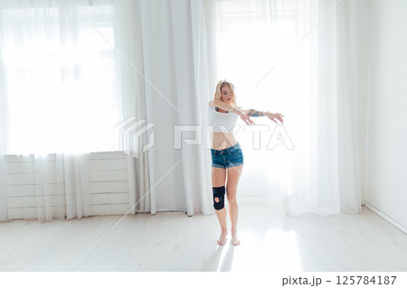 Blonde woman listening to music and dancing Blonde woman listening to music and dancing 125784187
