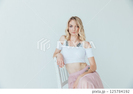 Portrait of a blonde woman in a summer light dress on a white background 125784192