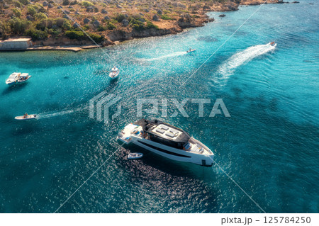 Aerial view of luxury yachts and boats in the crystal-clear sea 125784250