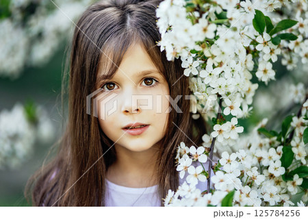 Young girl surrounded by blooming white cherry blossoms symbolizing love, family connection, and joyful celebration of Mother's Day in spring. warm spring greetings Young girl surrounded by blooming white cherry blossoms symbolizing love, family connection, and joyful celebration of Mother's Day in spring. warm spring greetings 125784256