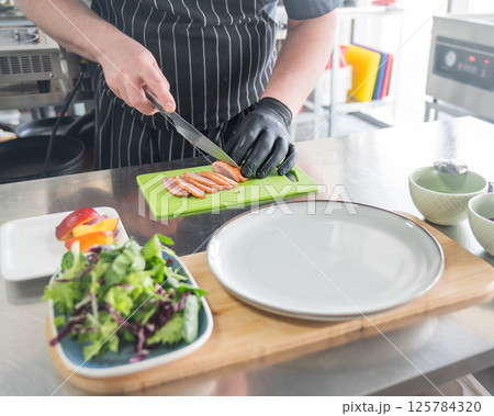 The chef slices the roast duck. The chef slices the roast duck. 125784320