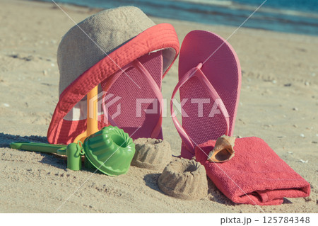 Different shapes made of sand, children toys for playing and accessories for relax on beach 125784348
