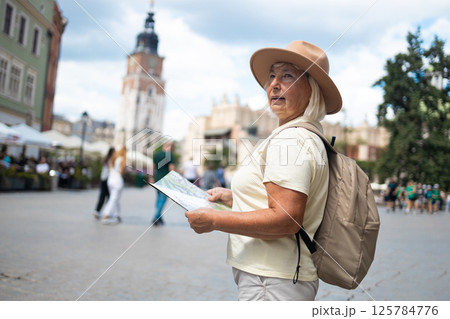 Senior woman exploring the city with a map, sightseeing in the square. 125784776