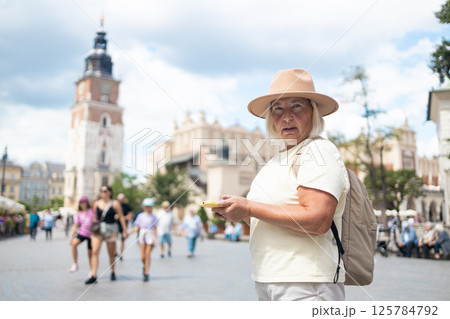 Senior woman exploring the city with a map, sightseeing in the square. 125784792